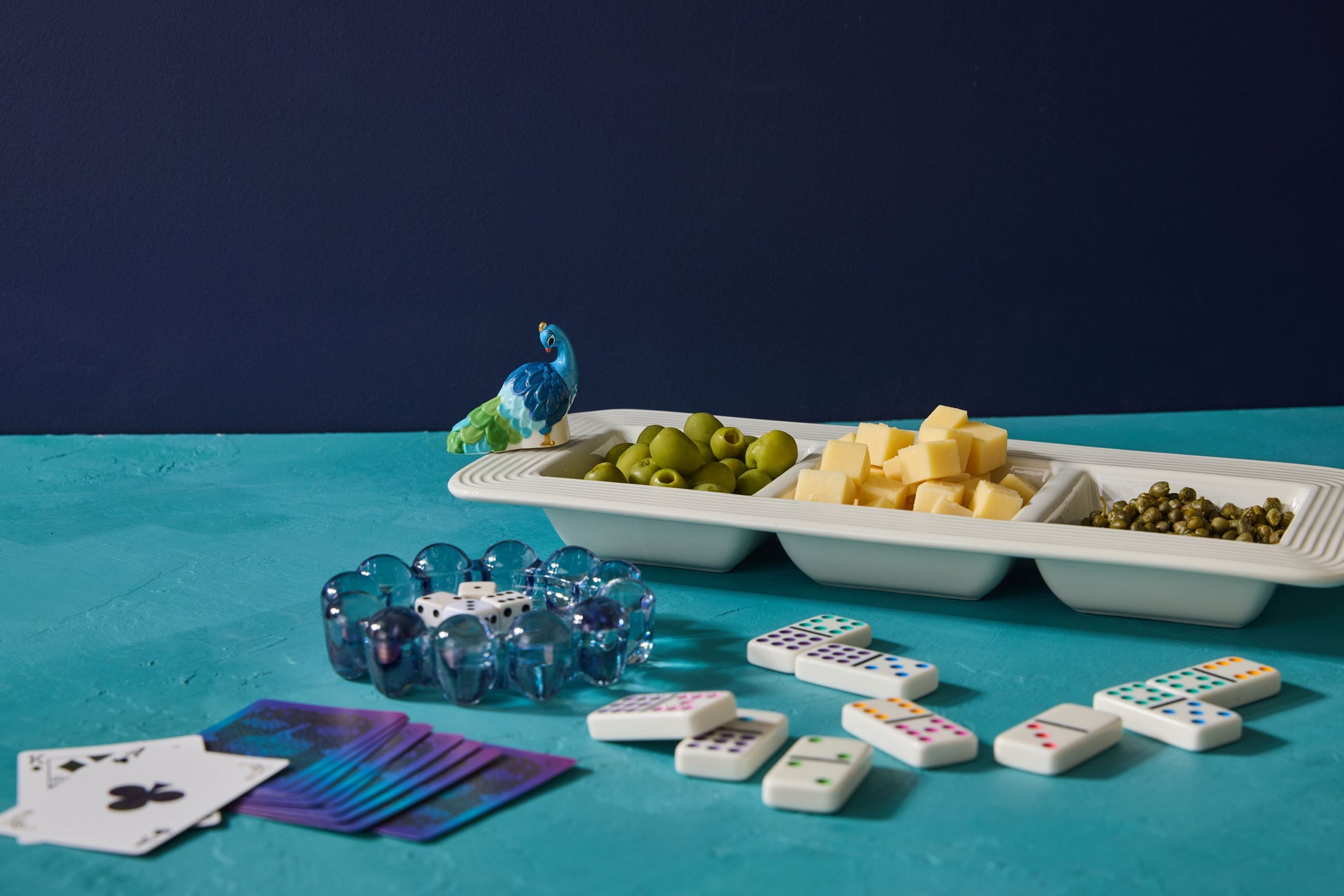 Assorted board game components including dice, cards, and dominoes on a blue surface with a dark background.